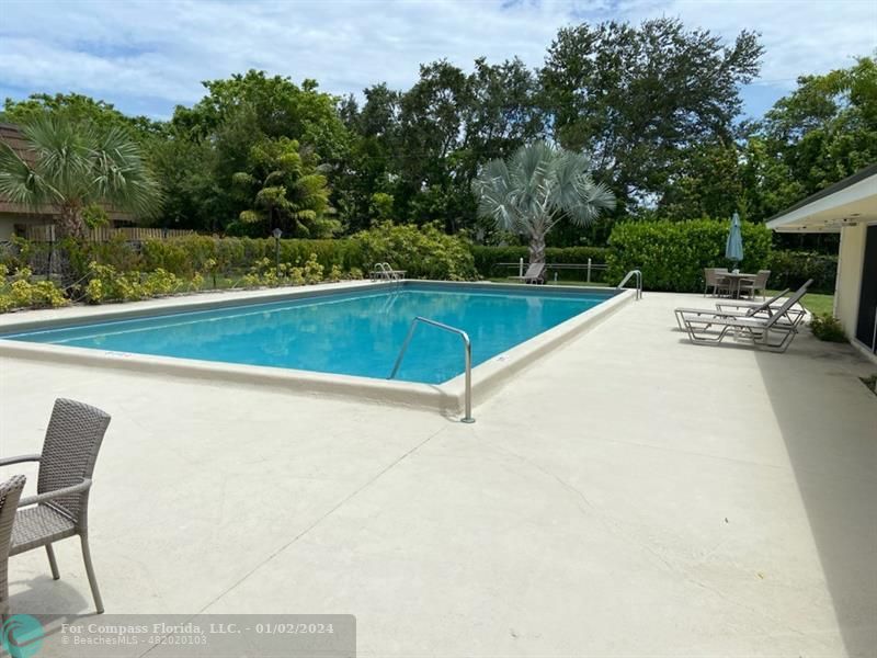 1166 6th Avenue, Unit A1 Vero Beach, FL 32960 - Photo 13 of 13 a view of a swimming pool with a yard and a bench