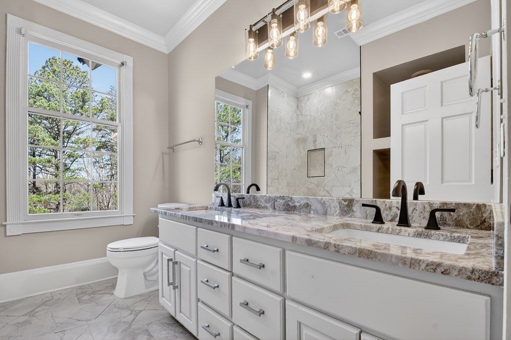 229 Crossroads Church Road Ellijay, GA 30540 - Photo 55 of 71 a bathroom with a granite countertop sink a large mirror a toilet and a window