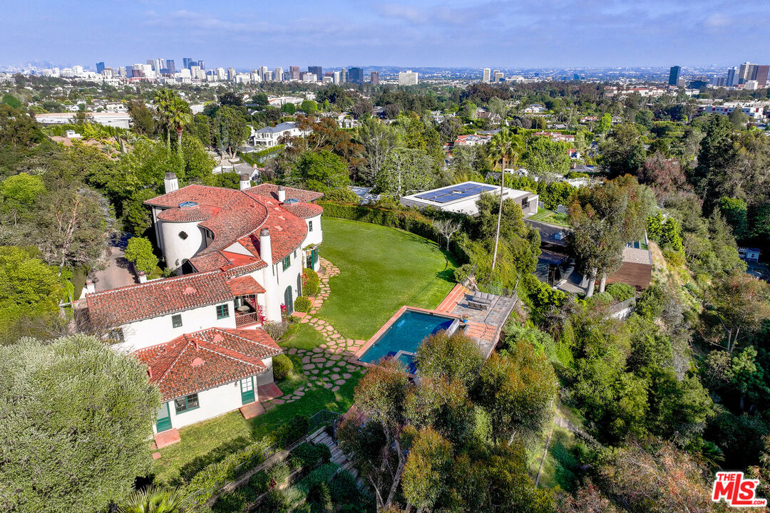 an aerial view of residential houses with outdoor space and trees