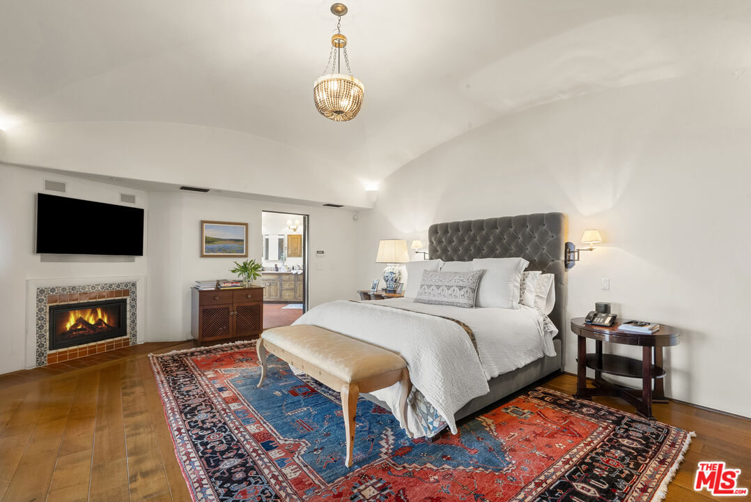 361 Fordyce Road Los Angeles, CA 90049 - Photo 17 of 40 a spacious bedroom with a bed and a fireplace