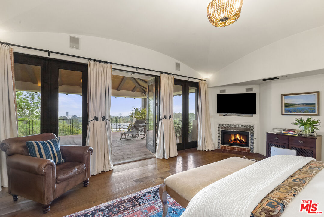 361 Fordyce Road Los Angeles, CA 90049 - Photo 18 of 40 a bedroom with furniture a flat screen tv and a fireplace