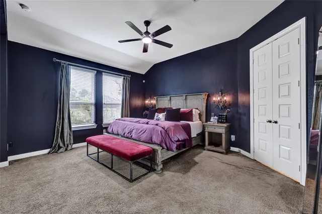 a spacious bedroom with a bed and a chandelier