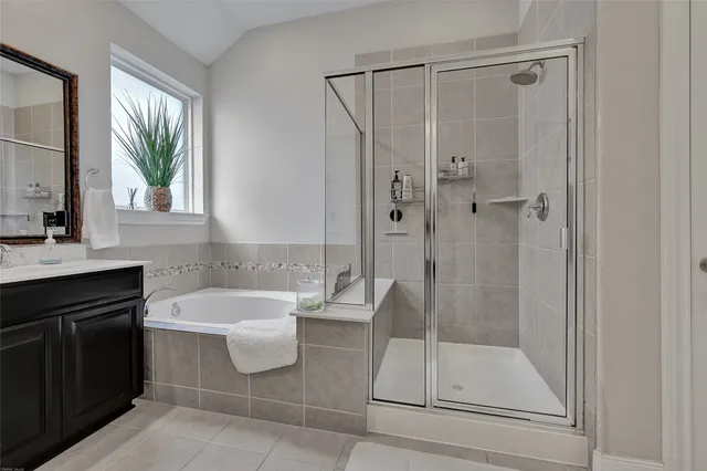 a bathroom with a bathtub a sink a vanity and a window