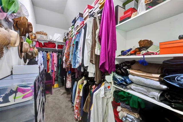 a view of walk in closet with clothes