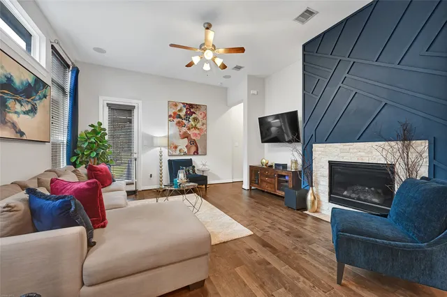 a living room with furniture a flat screen tv and a fireplace