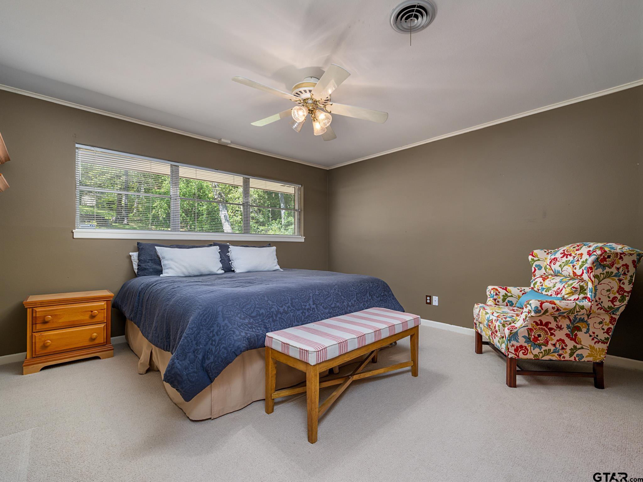 3203 Dinah Lane Tyler, TX 75701 - Photo 21 of 33 a bedroom with a bed and a chandelier