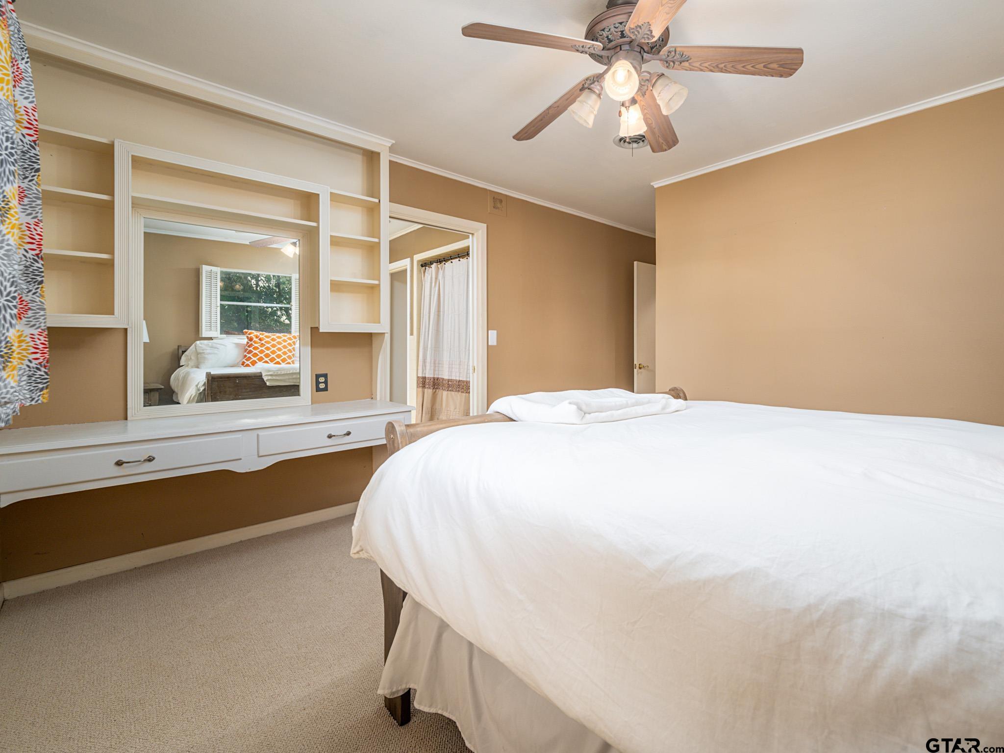 3203 Dinah Lane Tyler, TX 75701 - Photo 26 of 33 a spacious bedroom with a large bed and a chandelier fan