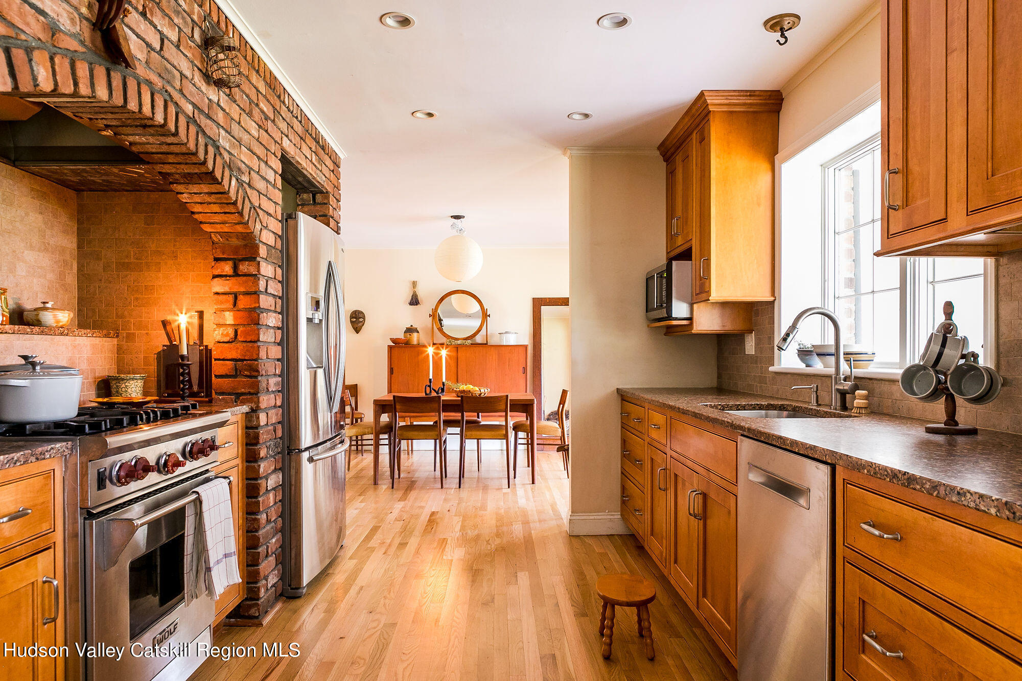 1234 Flatbush Road Kingston, NY 12401 - Photo 10 of 28 a kitchen with stainless steel appliances granite countertop a stove top oven a sink a dining table and chairs with wooden floor