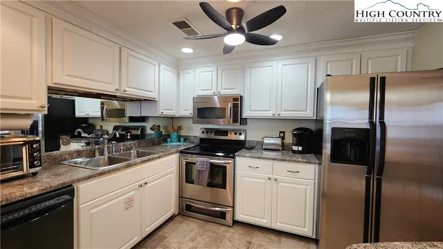 a kitchen with white cabinets and stainless steel appliances
