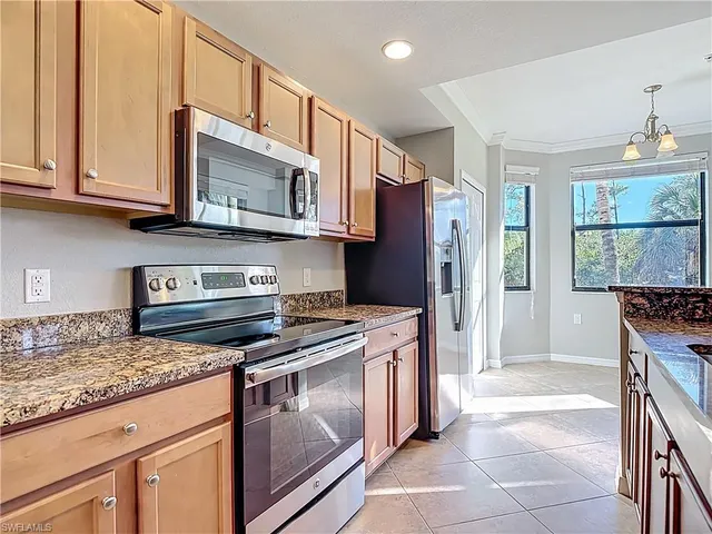 a kitchen with stainless steel appliances granite countertop a stove microwave and refrigerator