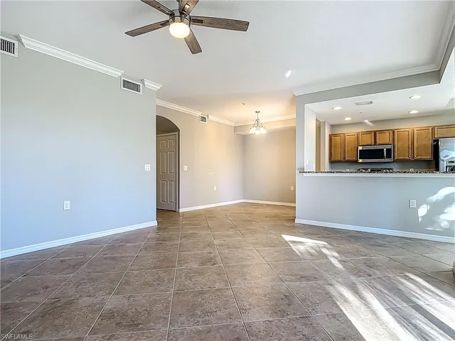 an empty room with a ceiling fan and a window