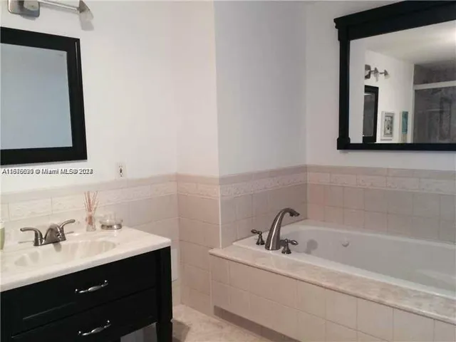 a bathroom with a toilet sink vanity and mirror
