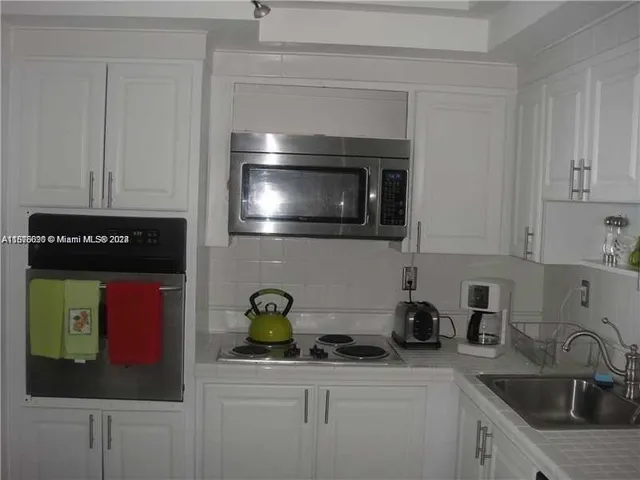 a kitchen with stainless steel appliances granite countertop a sink a stove and cabinets