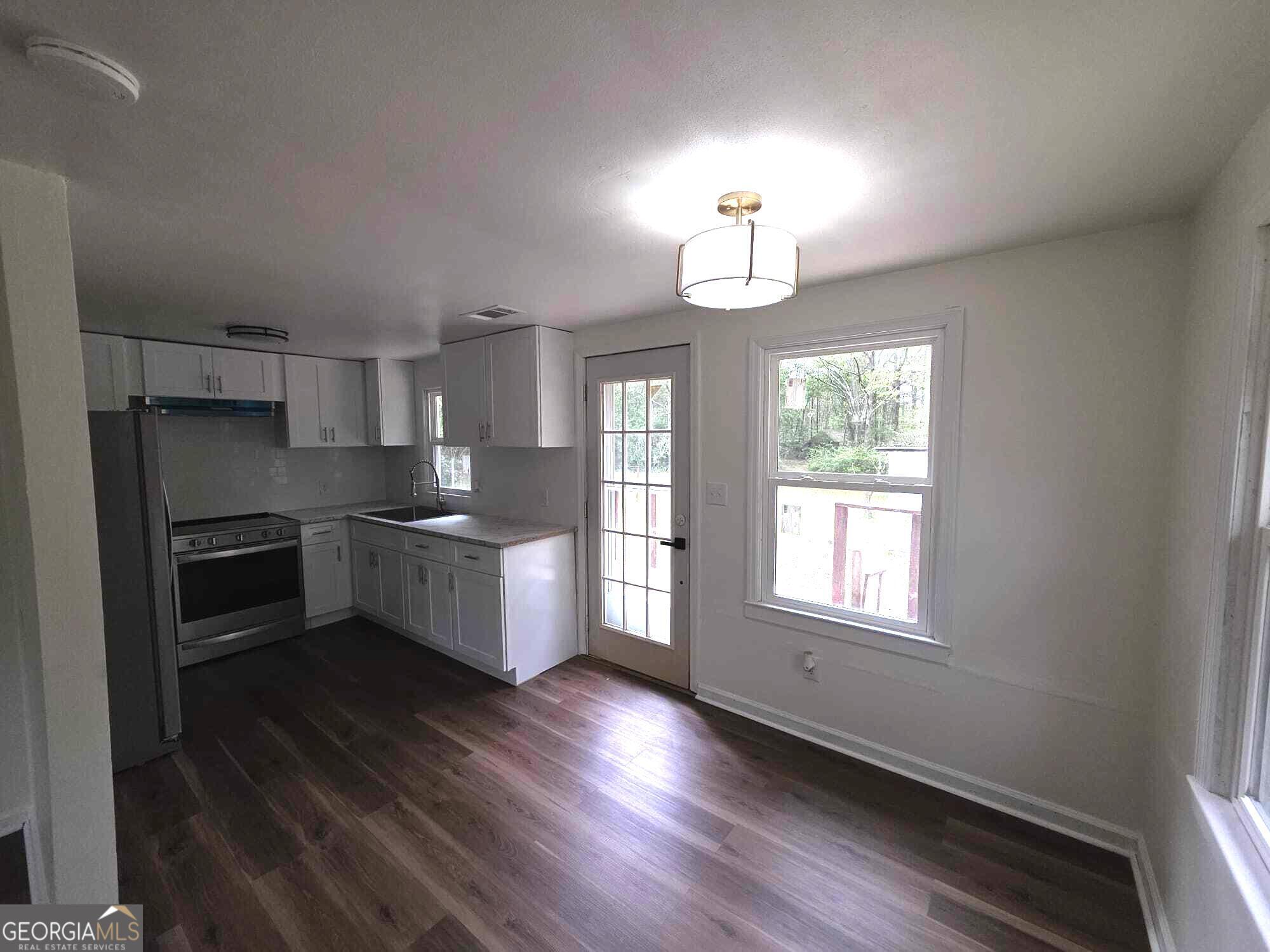 15 Dixie Drive Stockbridge, GA 30281 - Photo 11 of 36 a kitchen with granite countertop wooden floors stainless steel appliances and window