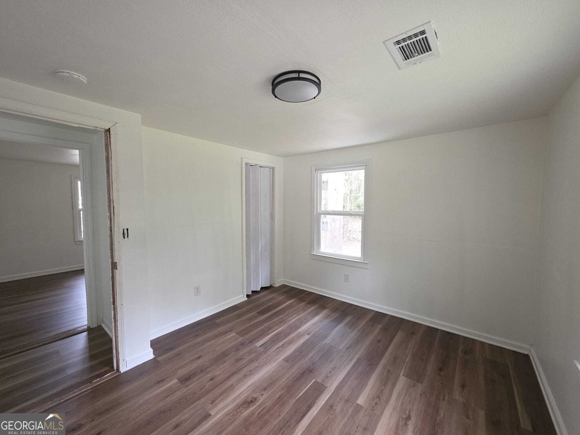 15 Dixie Drive Stockbridge, GA 30281 - Photo 13 of 36 an empty room with wooden floor and windows