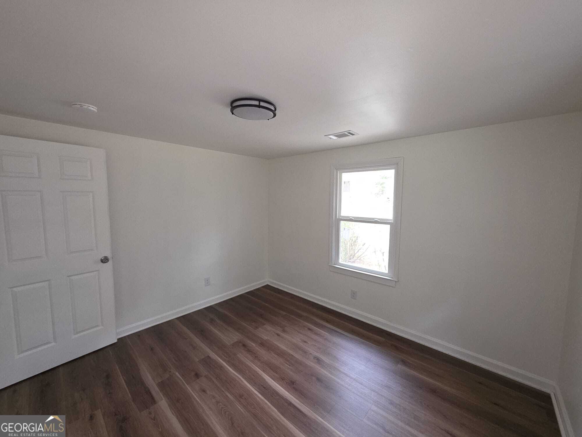 15 Dixie Drive Stockbridge, GA 30281 - Photo 23 of 36 an empty room with wooden floor and windows
