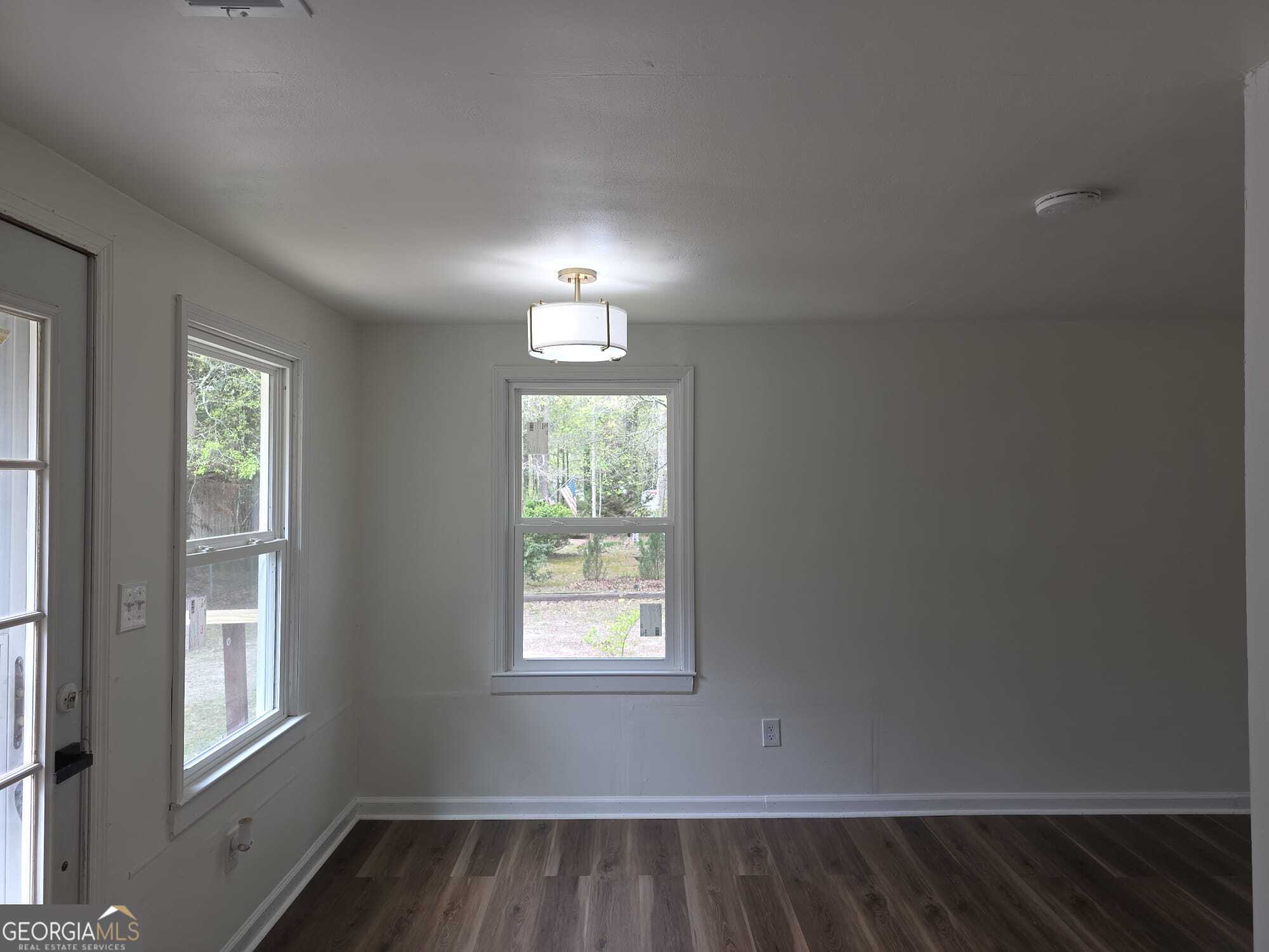 15 Dixie Drive Stockbridge, GA 30281 - Photo 25 of 36 an empty room with wooden floor chandelier and windows