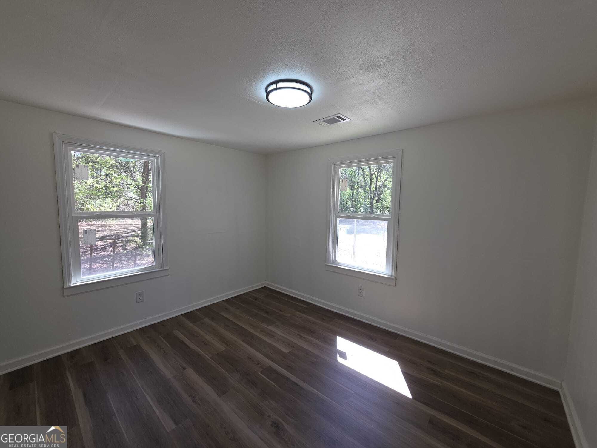 15 Dixie Drive Stockbridge, GA 30281 - Photo 32 of 36 a view of an empty room with wooden floor and a window