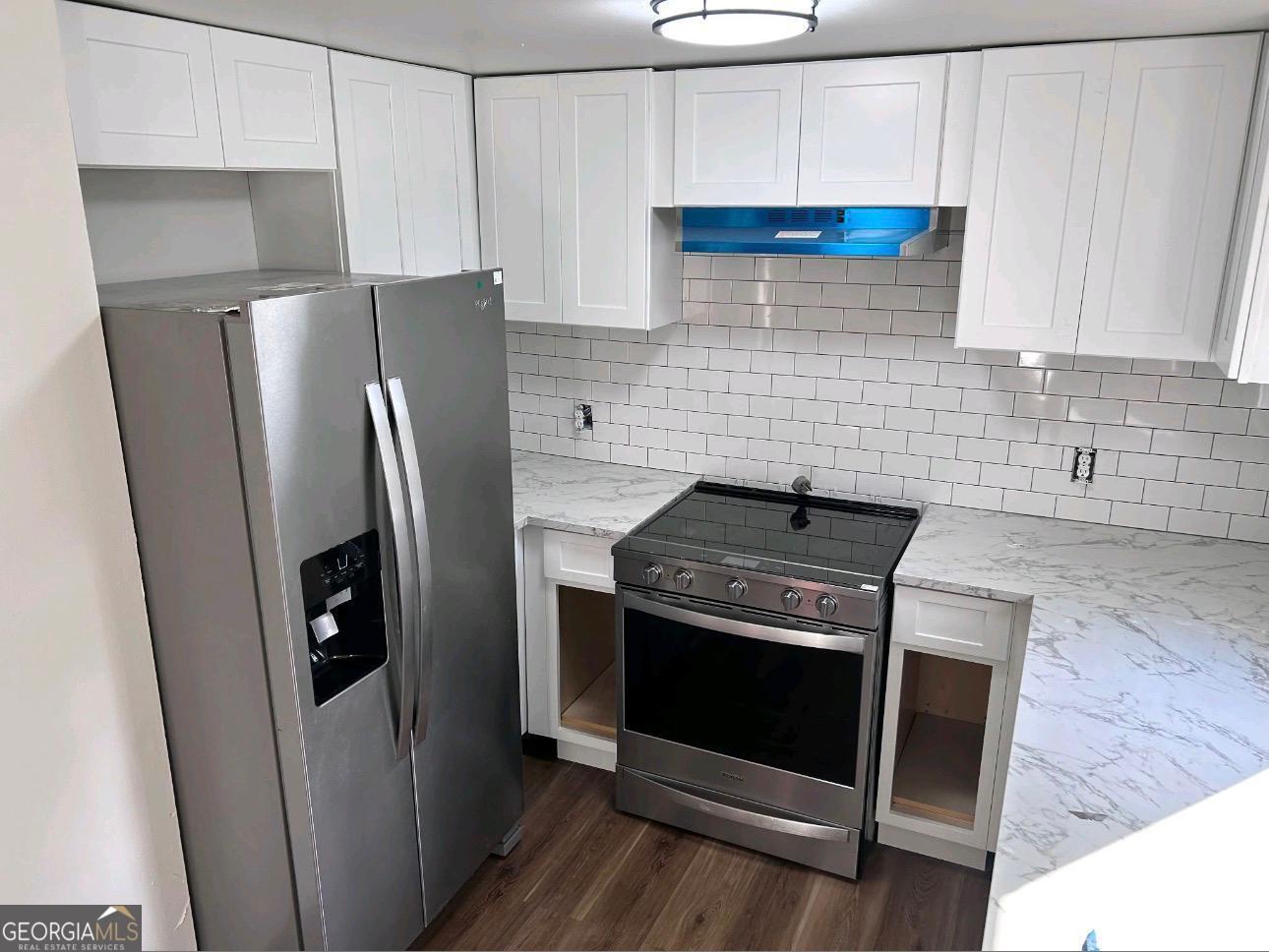15 Dixie Drive Stockbridge, GA 30281 - Photo 6 of 19 a kitchen with stainless steel appliances wooden floor sink and wooden cabinets