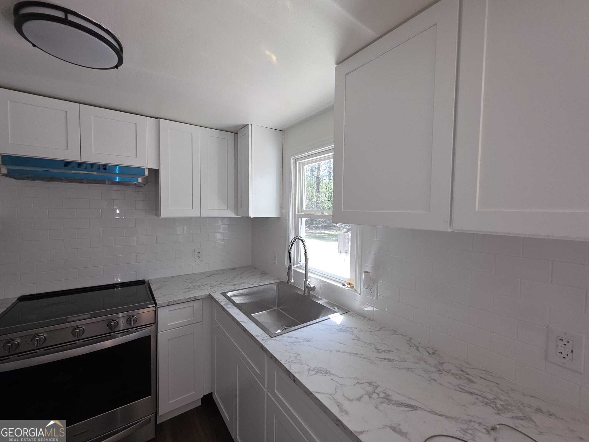15 Dixie Drive Stockbridge, GA 30281 - Photo 7 of 19 a kitchen with granite countertop a stove and a sink
