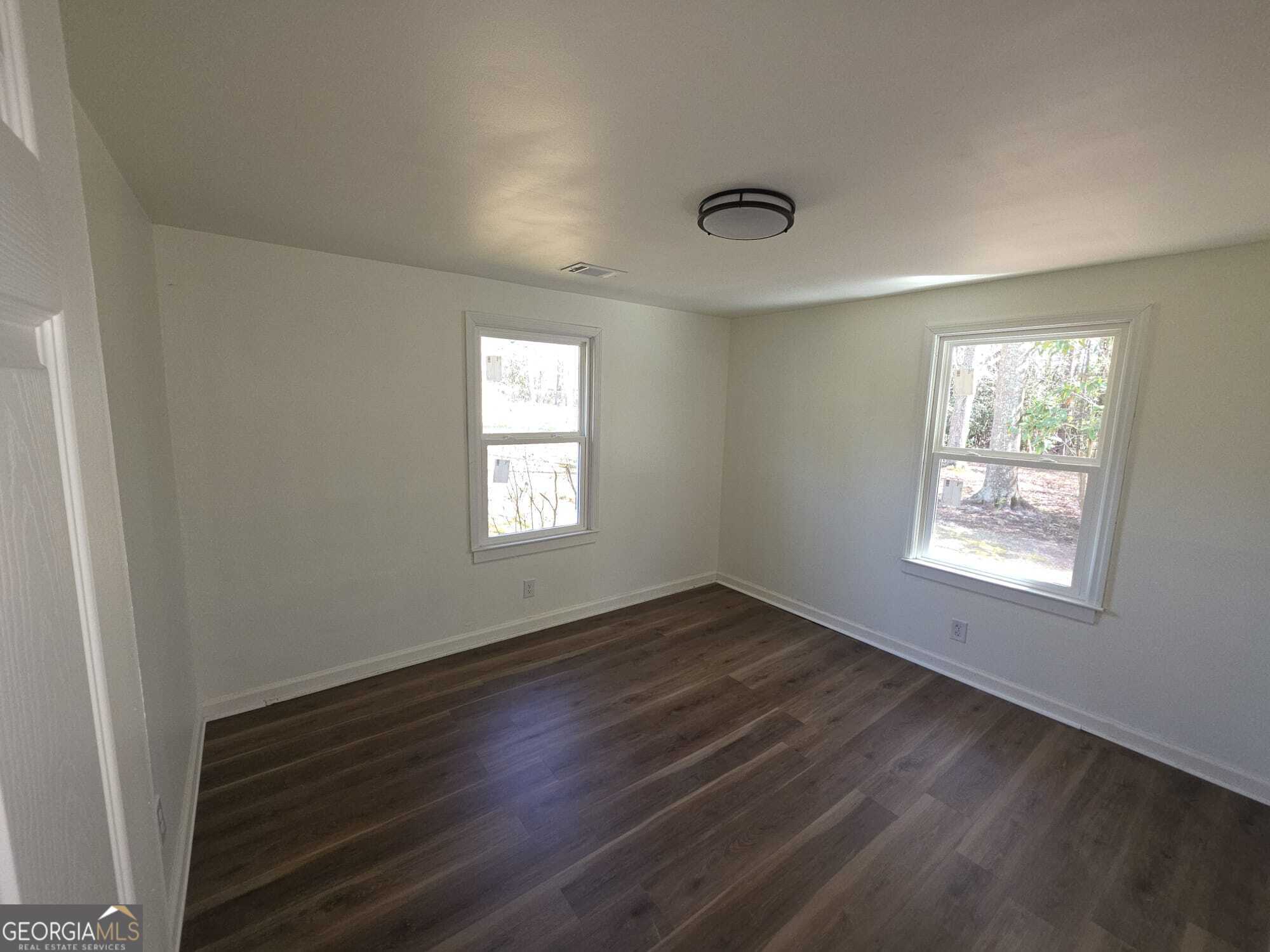 15 Dixie Drive Stockbridge, GA 30281 - Photo 9 of 19 an empty room with wooden floor and windows