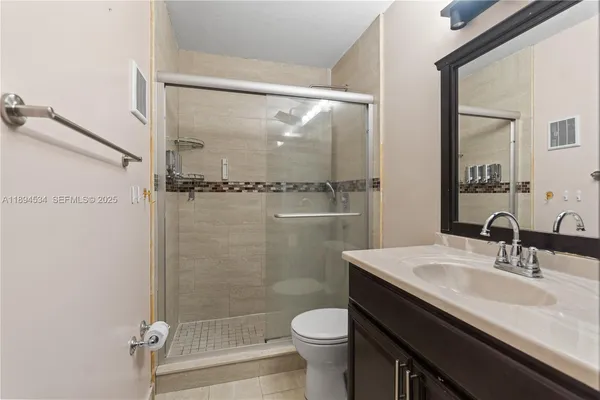 a bathroom with a sink a toilet a mirror and shower