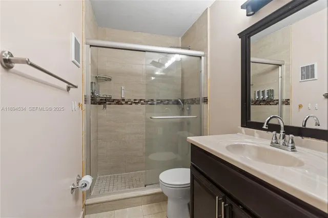 a bathroom with a sink a toilet a mirror and shower