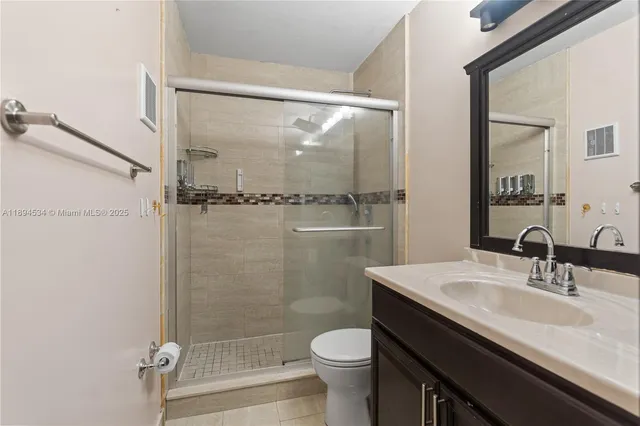 a bathroom with a sink a toilet a mirror and shower