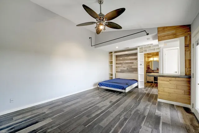 a view of room with wooden floor and ceiling fan