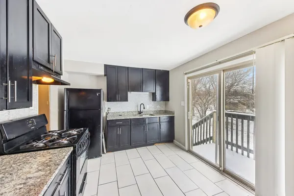 a kitchen with stainless steel appliances granite countertop a stove a sink and a refrigerator