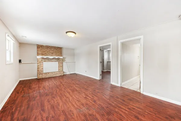 a view of empty room with wooden floor and window