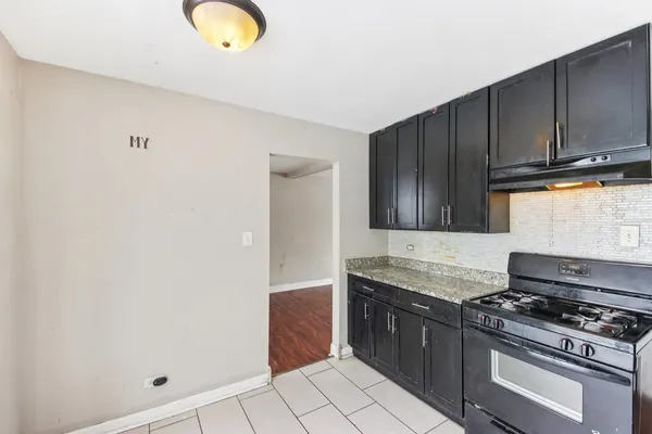 a kitchen with granite countertop a stove and a sink