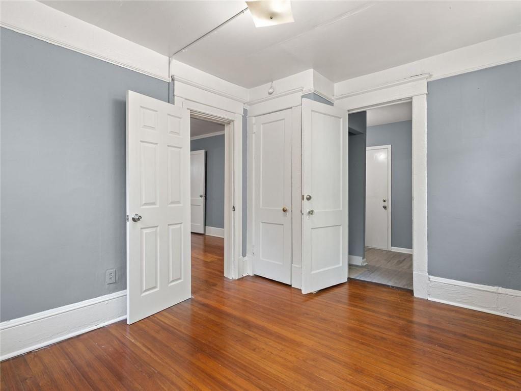 164 4th Street Northeast, Unit 9 Atlanta, GA 30308 - Photo 10 of 18 an empty room with wooden floor & closet and windows