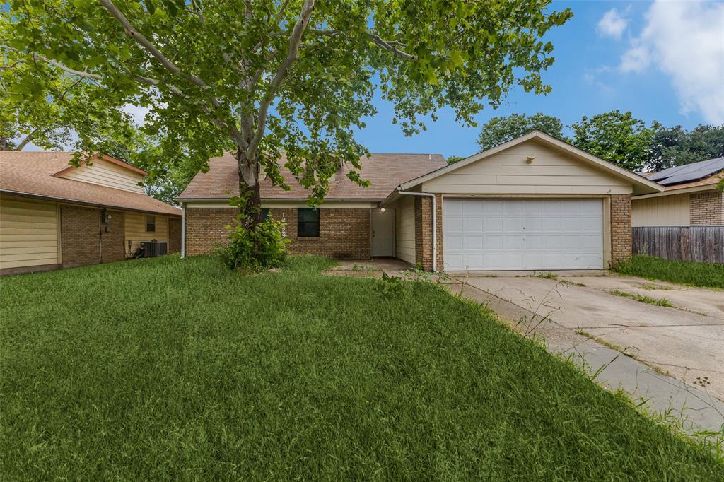 Ranch-style house featuring brick siding, a front lawn, driveway, and a garage