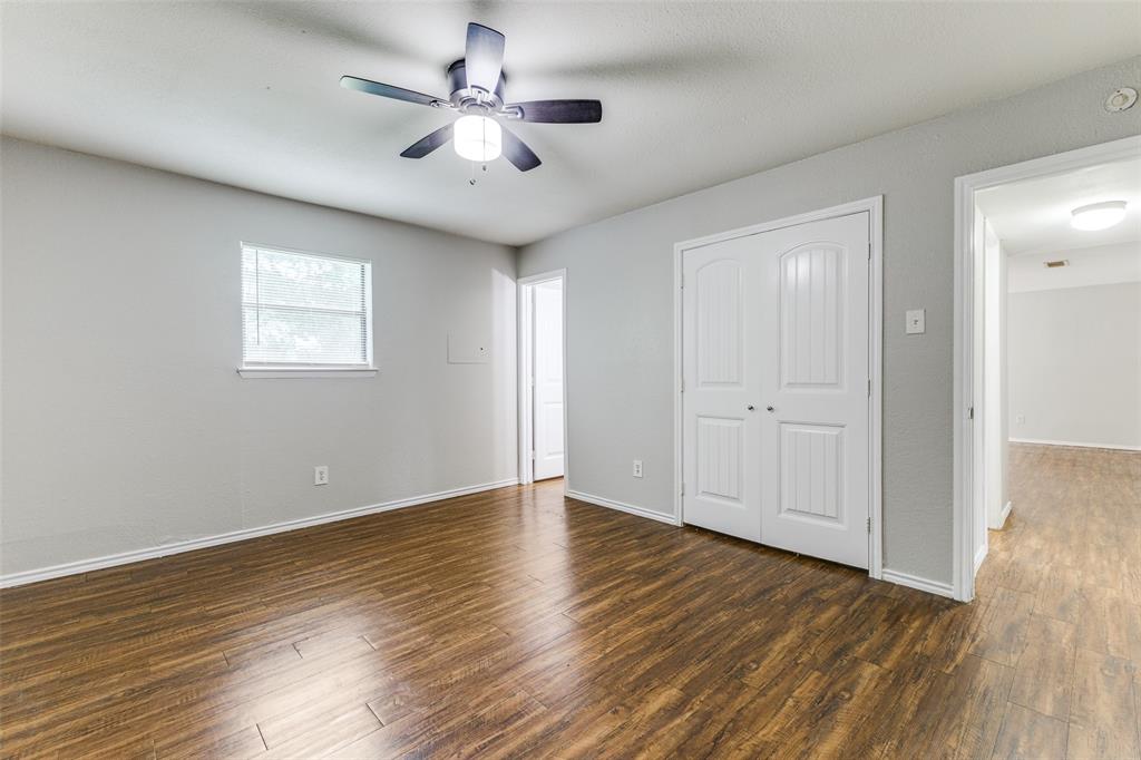 12129 Spring Branch Drive Balch Springs, TX 75180 - Photo 6 of 11 Unfurnished bedroom featuring dark wood finished floors, a ceiling fan, and a closet