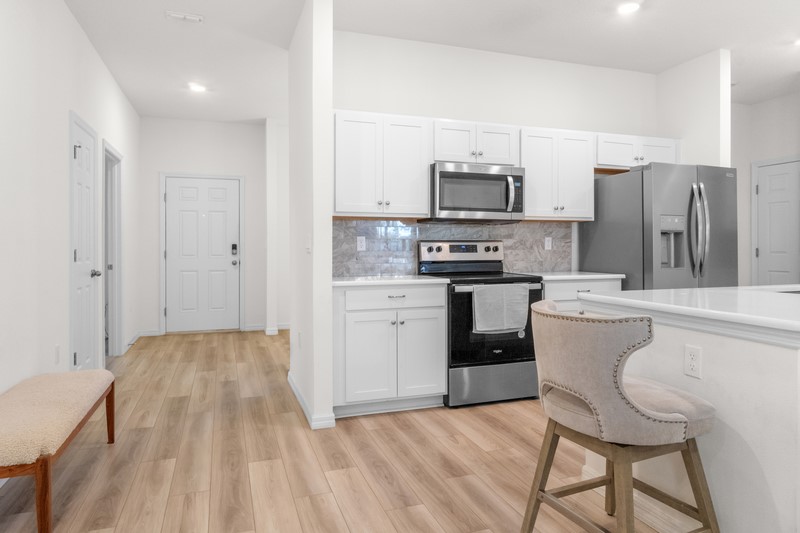 1014 Guava Street Sebastian, FL 32958 - Photo 13 of 30 a kitchen with stainless steel appliances a stove a sink dishwasher a refrigerator with a dining table and chairs
