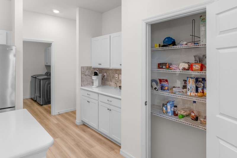 1014 Guava Street Sebastian, FL 32958 - Photo 19 of 30 a kitchen with white cabinets and with wooden floor