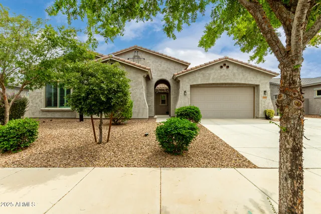 a front view of a house with a yard and trees
