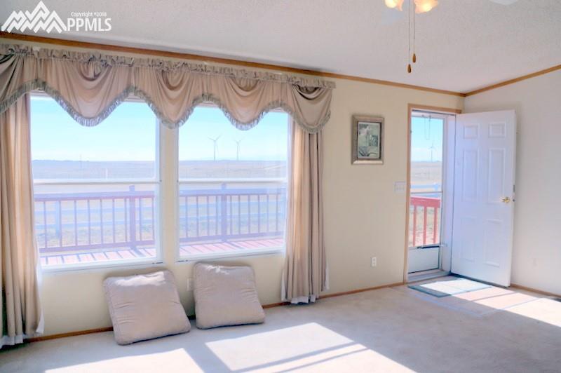 29360 Hanisch Road Calhan, CO 80808 - Photo 2 of 34 Large living room windows overlook the deck and Pikes Peak views!