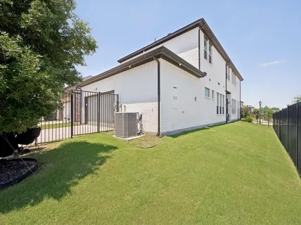 a view of a house with backyard and trees