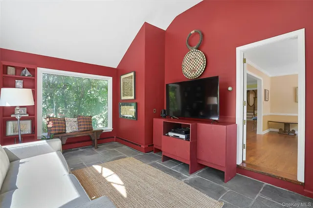 a living room with furniture a flat screen tv and a floor to ceiling window