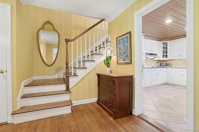 a view of a hallway with wooden floor and a living room