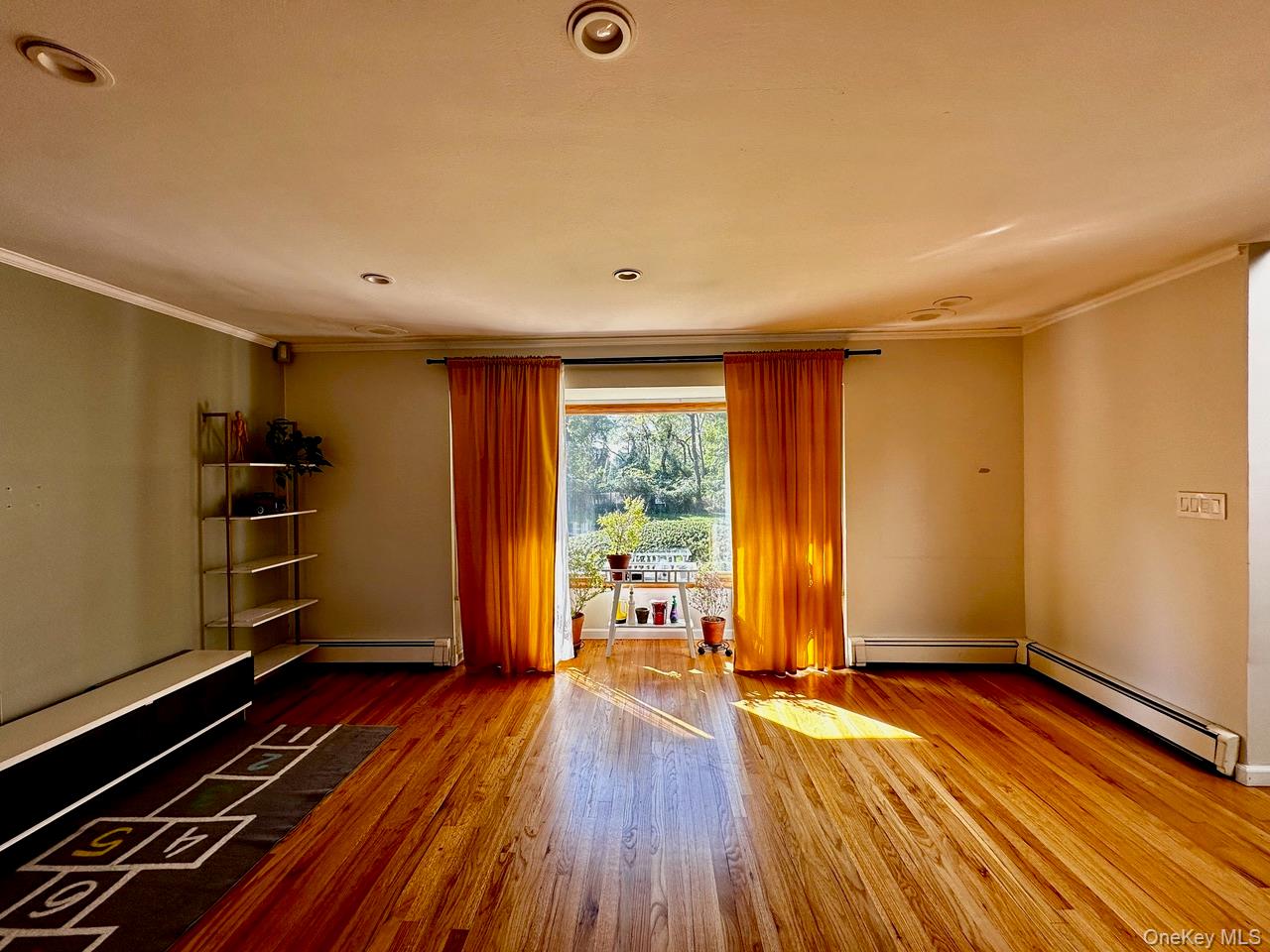26 Canterbury Road Woodbury, NY 11797 - Photo 3 of 17 wooden floor in an empty room with a window