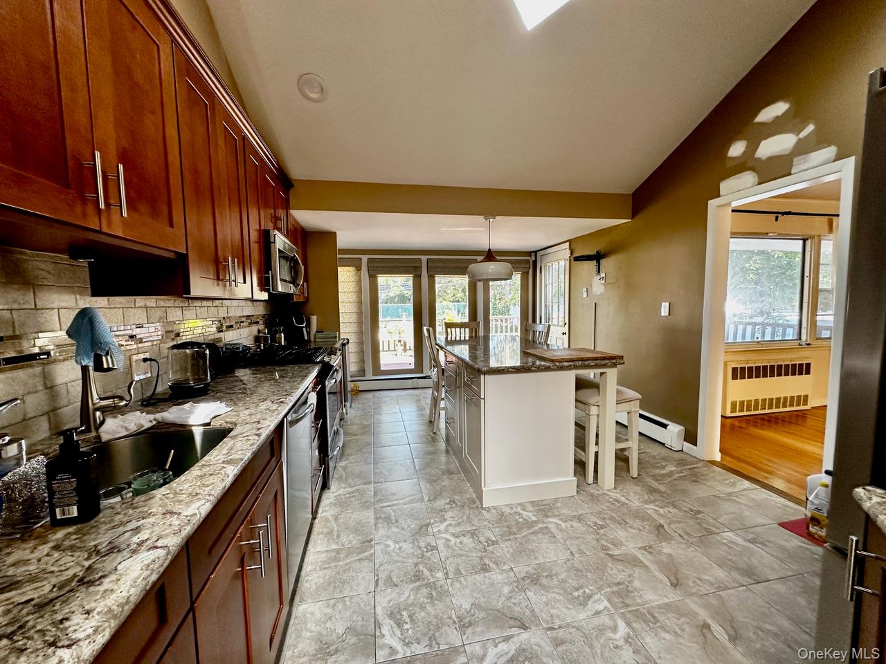 26 Canterbury Road Woodbury, NY 11797 - Photo 5 of 17 a kitchen with granite countertop a stove a sink and a refrigerator