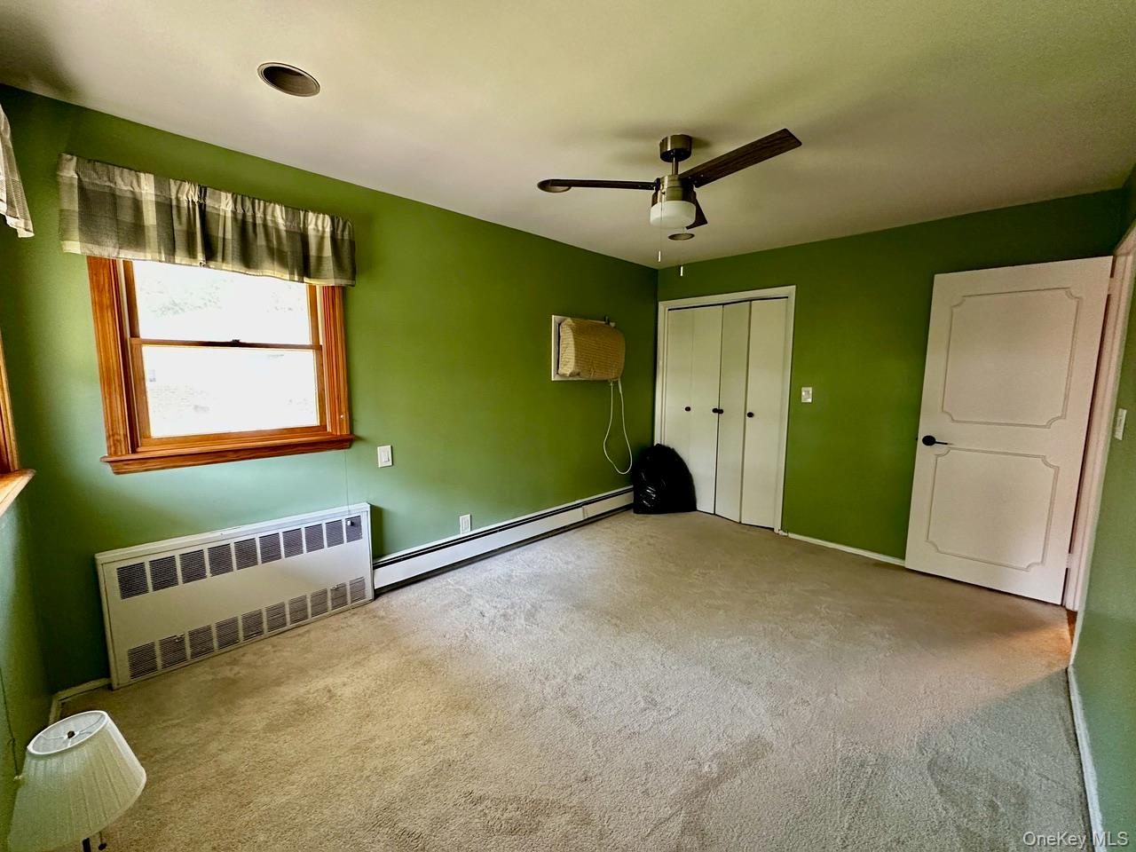26 Canterbury Road Woodbury, NY 11797 - Photo 6 of 17 a view of a livingroom with a ceiling fan & a window
