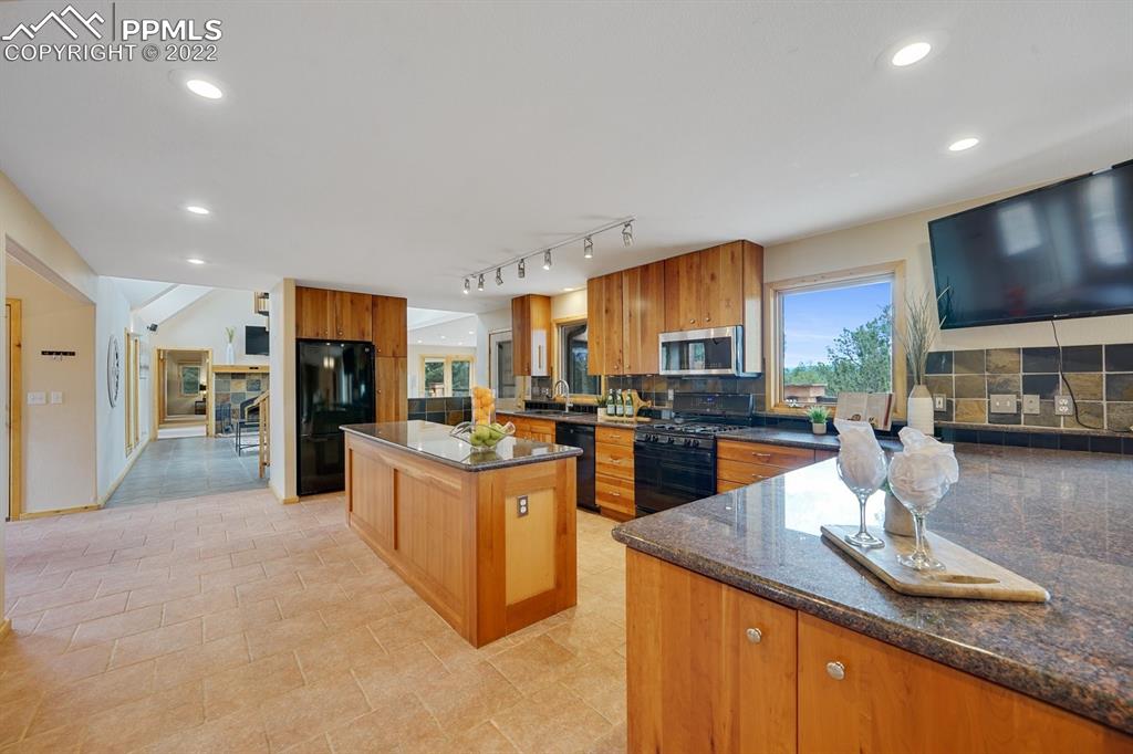 6900 Highway 24 Divide, CO 80814 - Photo 6 of 50 a kitchen with stainless steel appliances granite countertop a stove top oven a sink dishwasher a dining table and chairs with wooden floor