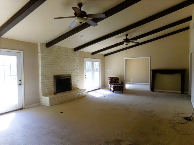 a view of empty room with fireplace and fan