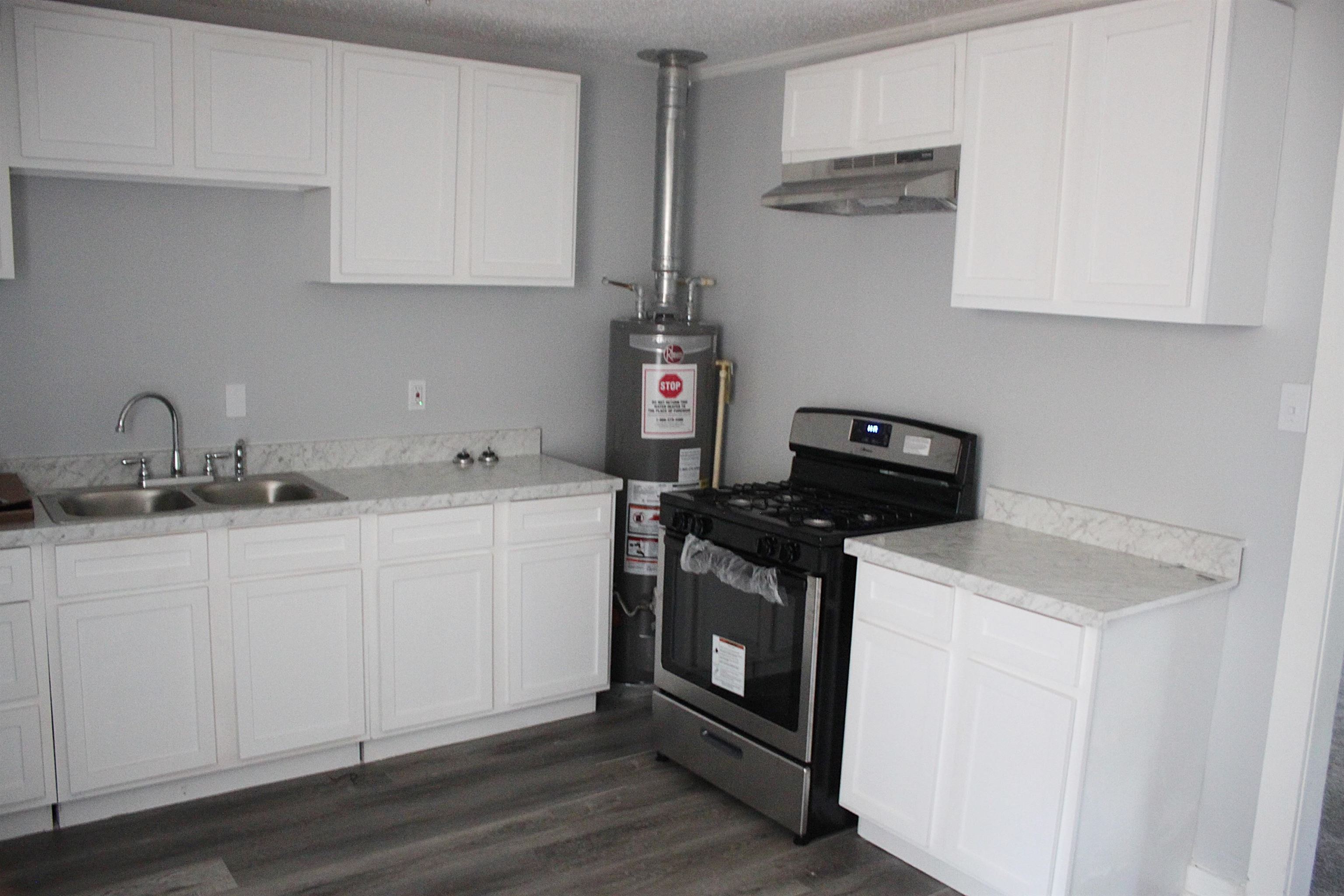 2633 Walnut Road Memphis, TN 38128 - Photo 6 of 6 a kitchen with stainless steel appliances granite countertop a sink stove and white cabinets
