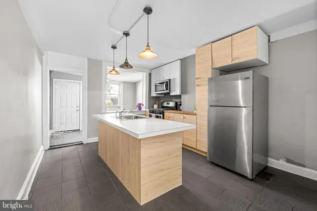a kitchen with a refrigerator a sink and dishwasher with wooden floor