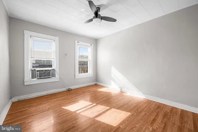 a view of a room with wooden floor and a ceiling fan